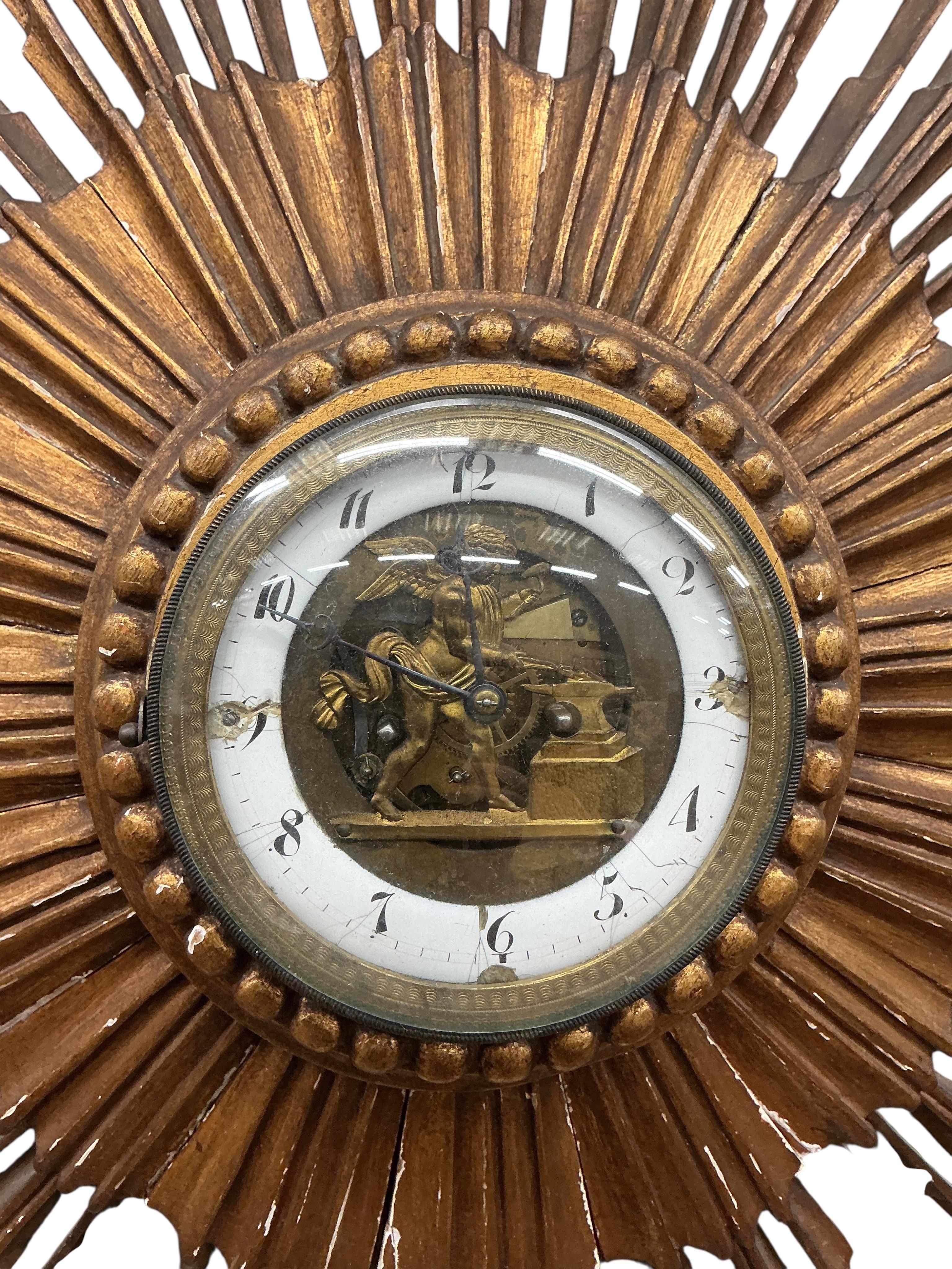 A French giltwood sunburst wall timepiece, with enamelled Roman chapter ring and visible figural escapement, diameter 62cm